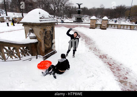 New York, États-Unis. 14Th Mar, 2017. Les jeunes gens jettent des boules après la prise d'un sèche tandis que la luge dans l'escalier près de la fontaine Bethesda de Central Park à New York pendant une tempête le 14 mars 2017, qui a été prédit à apporter jusqu'à deux pieds de neige à la ville mais seulement a 7 pouces. Les écoles fermées et la ville était relativement calme que beaucoup sont restés à la maison, mais certains se sont aventurés hors de s'amuser dans le parc. Crédit : Adam Stoltman/Alamy Live News Banque D'Images