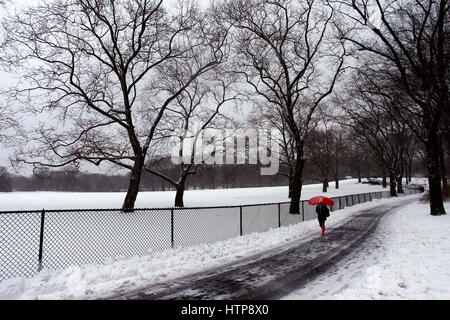 New York, États-Unis. 14Th Mar, 2017. Une femme jouit d'une promenade à travers la ville de New York's Central Park, pendant une tempête le 14 mars 2017, qui a été prédit à apporter jusqu'à deux pieds de neige à la ville mais seulement a 7 pouces. Les écoles fermées et la ville était relativement calme que beaucoup sont restés à la maison, mais certains se sont aventurés hors de s'amuser dans le parc. Crédit : Adam Stoltman/Alamy Live News Banque D'Images