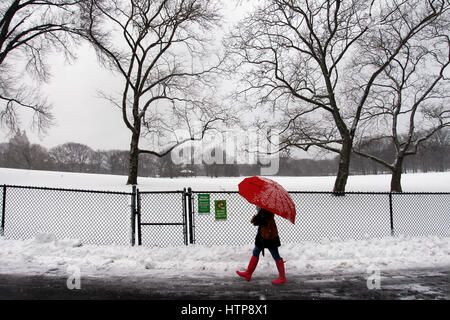 New York, États-Unis. 14Th Mar, 2017. Une femme jouit d'une promenade à travers la ville de New York's Central Park, pendant une tempête le 14 mars 2017, qui a été prédit à apporter jusqu'à deux pieds de neige à la ville mais seulement a 7 pouces. Les écoles fermées et la ville était relativement calme que beaucoup sont restés à la maison, mais certains se sont aventurés hors de s'amuser dans le parc. Crédit : Adam Stoltman/Alamy Live News Banque D'Images