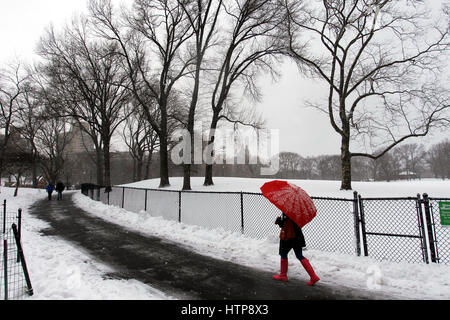 New York, États-Unis. 14Th Mar, 2017. Une femme jouit d'une promenade à travers la ville de New York's Central Park, pendant une tempête le 14 mars 2017, qui a été prédit à apporter jusqu'à deux pieds de neige à la ville mais seulement a 7 pouces. Les écoles fermées et la ville était relativement calme que beaucoup sont restés à la maison, mais certains se sont aventurés hors de s'amuser dans le parc. Crédit : Adam Stoltman/Alamy Live News Banque D'Images