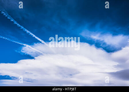Hdr dramatique ciel bleu avec d'énormes nuages blancs moelleux et les pistes, traces de jet Banque D'Images