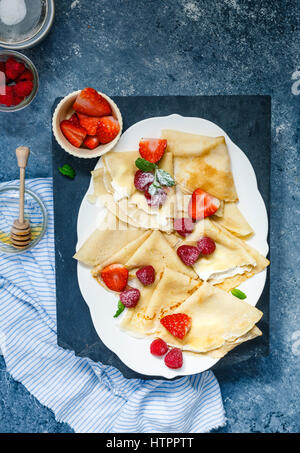 Crêpes garnies de crème, fruits rouges, sucre glace Banque D'Images