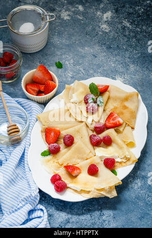 Crêpes garnies de crème, fruits rouges, sucre glace Banque D'Images