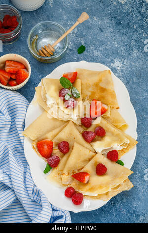 Crêpes garnies de crème, fruits rouges, sucre glace Banque D'Images