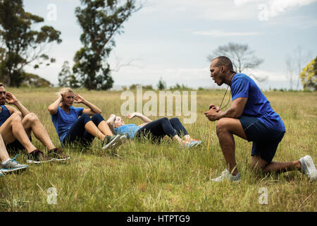 Mettre en place les personnes qui font de l'exercice de flexions dans bootcamp Banque D'Images