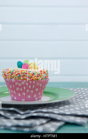 Close-up of cupcake avec oeufs de Pâques servi dans la plaque sur une serviette Banque D'Images