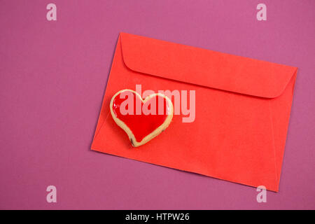 Close-up of happy mother day card, forme de coeur cookie sur fond rose contre l'enveloppe rouge Banque D'Images