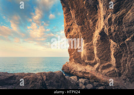 Chemin menant à travers les grot au coucher du soleil en Crimée. Beau paysage avec cave, pierres, rochers, sentier, mer et ciel bleu avec des nuages dans la soirée. T Banque D'Images