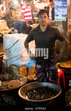 SRIMANGAL, BANGLADESH - Février 2017 : l'homme avec une petite boutique vendant du poisson dans le marché central bazar dans Srimangal, Bangladesh Banque D'Images