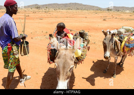 KENYA Samburu, Marsabit, tribu pastorale femme avec enfants sur donkey errer avec leurs troupeaux à la recherche d'eau et de pâturages / KENYA, Samburu, Marsabit Familie mit auf Wanderschaft Eseln und Ziegenherde, Suche nach Wasser und Weideland fuer ihre Tiere Banque D'Images