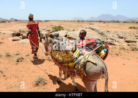 KENYA Samburu, Marsabit, tribu pastorale femme avec enfants sur donkey errer avec leurs troupeaux à la recherche d'eau et de pâturages / KENYA, Samburu, Marsabit Familie mit auf Wanderschaft Eseln und Ziegenherde, Suche nach Wasser und Weideland fuer ihre Tiere Banque D'Images