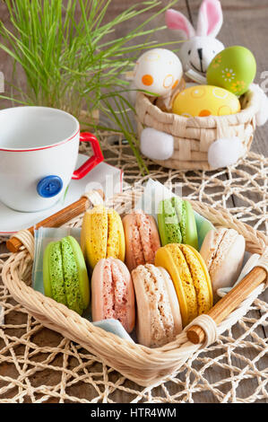 Macarons meringues multicolores dans un panier pour Pâques Banque D'Images