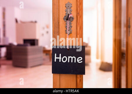 Le mot accueil on chalkboard hanging from key en face de salon Banque D'Images