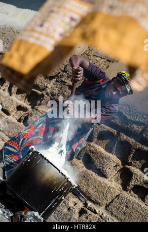 Une femme prépare du nshima, porridge, zambien traditionnelles pour le déjeuner à la maison du bonheur pour les enfants handicapés à Lusaka, Zambie. La maison du Bonheur est un orphelinat centre fondé en 2015 par Bernadetta Mindeo. Il y a 62 enfants dans le centre, 25 d'entre eux vivent dans la maison du bonheur en permanence. Vingt bénévoles prennent soin des garçons et des filles ayant différents types de handicaps. La maison du bonheur est situé dans deux pièces immeuble sans installations. Les bénévoles préparent les aliments sur le feu, lavez les vêtements pour enfants à l'extérieur. Banque D'Images