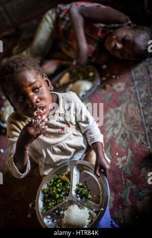 Une fille mange du nshima, porridge traditionnel pendant le déjeuner, la Zambie à la maison du bonheur pour les enfants handicapés à Lusaka, Zambie. La maison du Bonheur est un orphelinat centre fondé en 2015 par Bernadetta Mindeo. Il y a 62 enfants dans le centre, 25 d'entre eux vivent dans la maison du bonheur en permanence. Vingt bénévoles prennent soin des garçons et des filles ayant différents types de handicaps. La maison du bonheur est situé dans deux pièces immeuble sans installations. Les bénévoles préparent les aliments sur le feu, lavez les vêtements pour enfants à l'extérieur. Banque D'Images