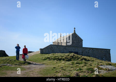 Deux hommes, l'un de prendre une photo, se tiennent près de l'ancienne chapelle de Saint Nicolas à St Ives, Cornwall, England, UK. Banque D'Images