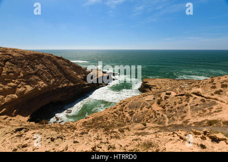 Littoral coloré avec une vue sur une petite baie à quelques camps de pêche dans le Parc National de Souss-Massa à l'océan Atlantique en Morooco, Afrique. Banque D'Images