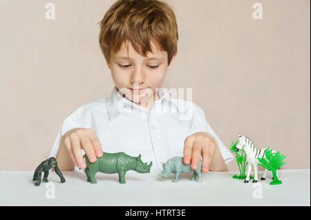 Little Boy is playing with toy animaux d'Afrique. l'enfance. Concept d'apprentissage Banque D'Images