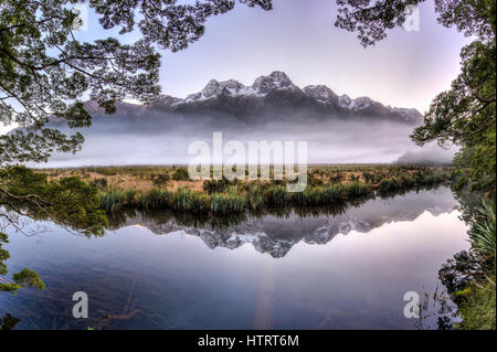 Reflets dans le miroir parfait lacs le long de la route de Milford Sound. Banque D'Images