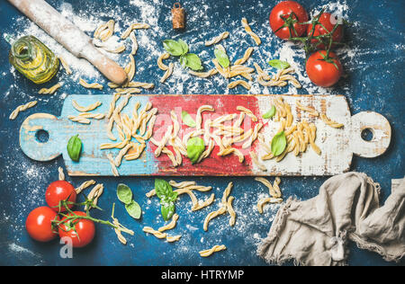 L'Italien casarecce, cherry-tomates, les feuilles de basilic et l'huile d'olive à bord Banque D'Images