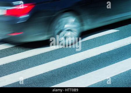 L'horizontale vue latérale d'une voiture noire avec le flou d'excès de vitesse sur un passage pour piétons Banque D'Images