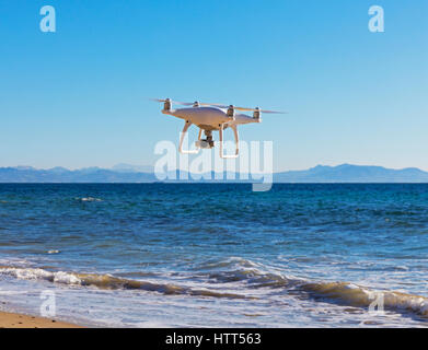 DJI Phantom 4 drone avec à bord de l'appareil photo au-dessus de la mer. Côtes du Maroc en arrière-plan. Banque D'Images