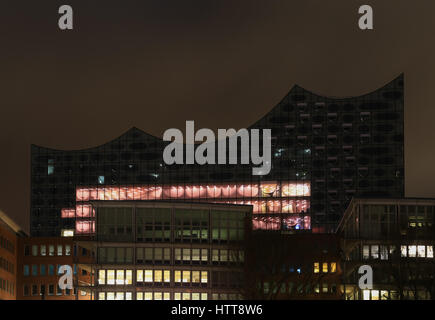 Hambourg, Allemagne - 9 mars 2017 : l'elbe Philharmonic Hall dans la zone du port Hafencity derrière plusieurs édifices dans la nuit. Banque D'Images