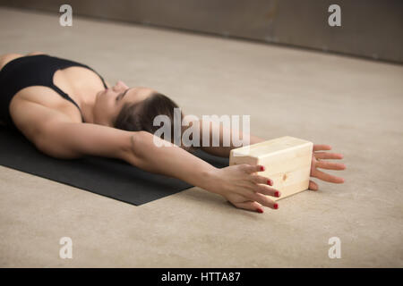 Young attractive woman practicing yoga Iyengar à l'aide de bloc Banque D'Images