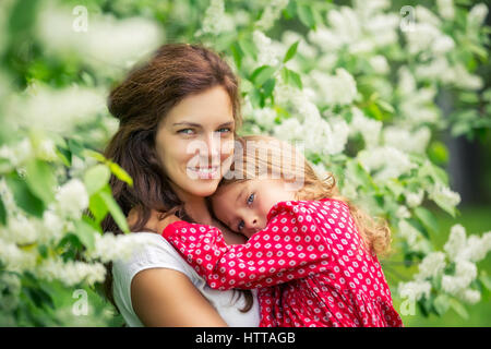 Portrait de mère heureuse et petite fille dans spring park Banque D'Images