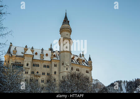 Gros plan sur le château de Neuschwanstein tôt le matin en hiver avec des arbres couverts de neige Banque D'Images