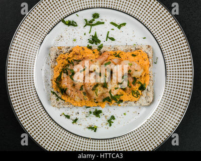 Langoustines en bonne santé avec du hoummos sur pain de seigle snack Banque D'Images