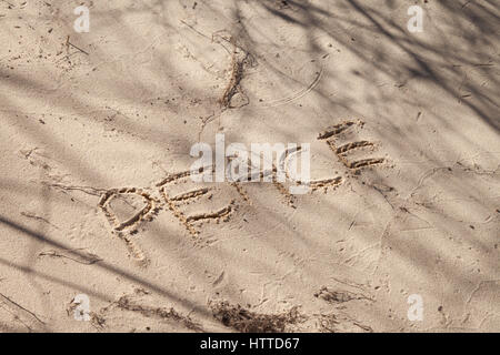 Le mot paix écrit dans le sable sur la plage Banque D'Images