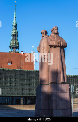 Monument des tirailleurs lettons sur la vieille ville de Riga, capitale de la République de Lettonie. Tour de l'église Saint Pierre sur l'arrière-plan Banque D'Images