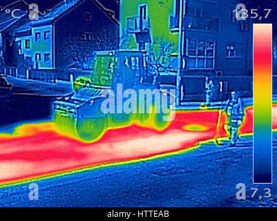 Thermovision infrarouge image montrant les travailleurs sur l'asphaltage de la machine à paver la route pendant la réparation de la rue fonctionne Banque D'Images