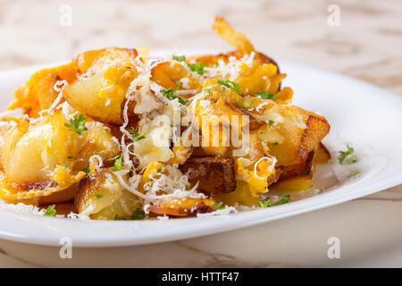 Frites avec les oeufs et le parmesan écrasé avec des herbes on white plate Banque D'Images