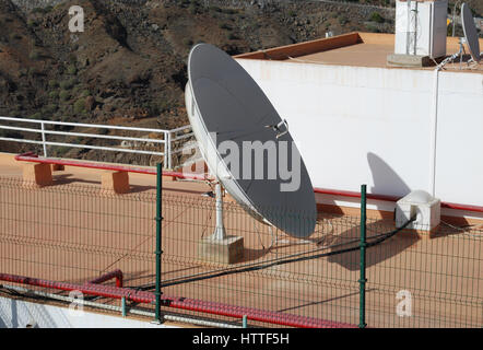 Antenne satellite sur le toit de la maison. La communication. Banque D'Images