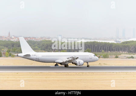 Avion blanc entièrement Airbus A320, de la compagnie aérienne, l'atterrissage est SmartLynx sur Madrid - Barajas, Adolfo Suarez l'aéroport. Nuageux jour de l'été Banque D'Images