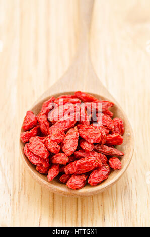 Sol en bois cuillère à soupe de baies de goji séchées sur fond de bois. Banque D'Images