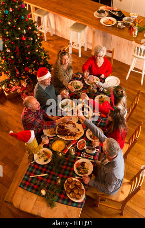 Coup de au-dessus d'une famille assis pour avoir un dîner de Noël. Ils sont tous l'éducation d'un verre, d'utilisation. Banque D'Images