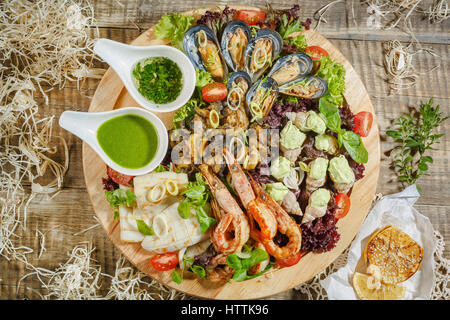 Huîtres sur glace pilée avec un couteau à huîtres et fruits de citron avec fourche argent et perles sur une plaque d'étain sur une plaque de marbre. Les huîtres ouvertes sur métal Banque D'Images