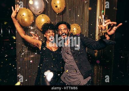 Photo de couple énergique de danser dans la boîte de nuit. Young man and woman having fun at pub partie. Banque D'Images