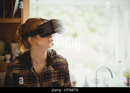 Femme victime de casque de réalité virtuelle dans la cuisine Banque D'Images