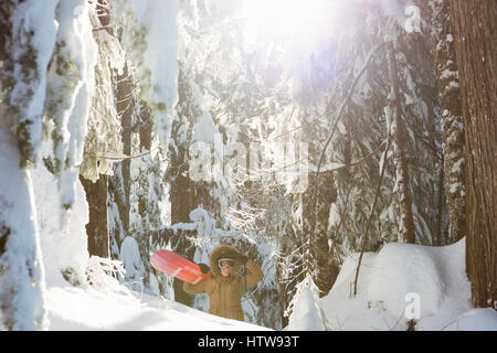 Femme avec snowboard marche sur la montagne enneigée Banque D'Images