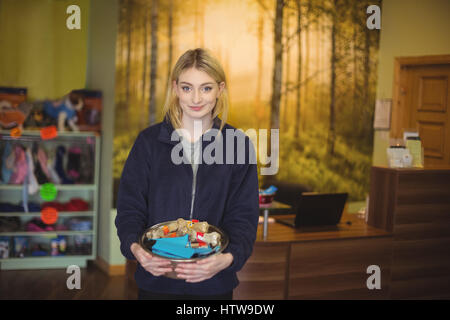 Woman holding bowl of dog bones en boutique Banque D'Images