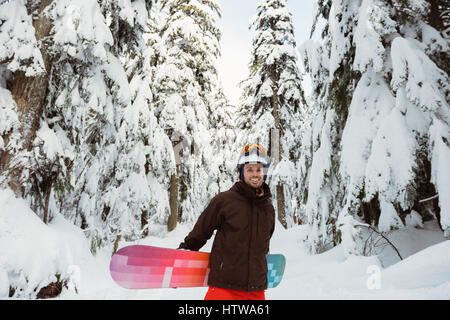 Homme debout et tenant un snowboard Banque D'Images