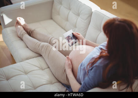 Pregnant woman relaxing on sofa et à l'échographie à Banque D'Images