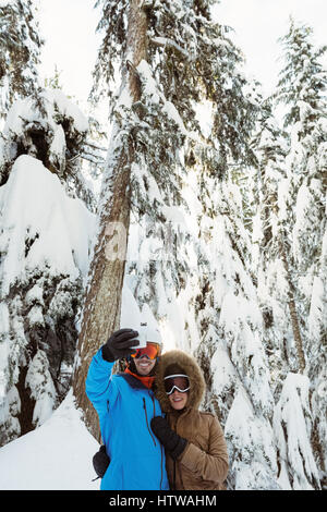 Prendre une couple de skieurs sur selfies paysage de neige Banque D'Images