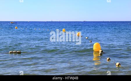 Bouées jaunes et corde montrant la zone baignade dans une mer bleu clair Banque D'Images