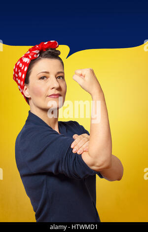 Résistant et sûr de femme avec un poing serré retrousser sa manche, bulle vide avec de l'espace texte, hommage à l'icône américaine à riveter Rosie Banque D'Images
