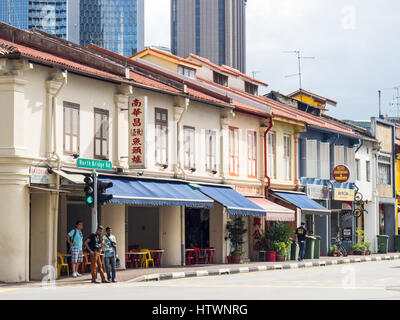 Les piétons en face d'une rangée de maisons-boutiques sur North Beach Road Singapour. Banque D'Images